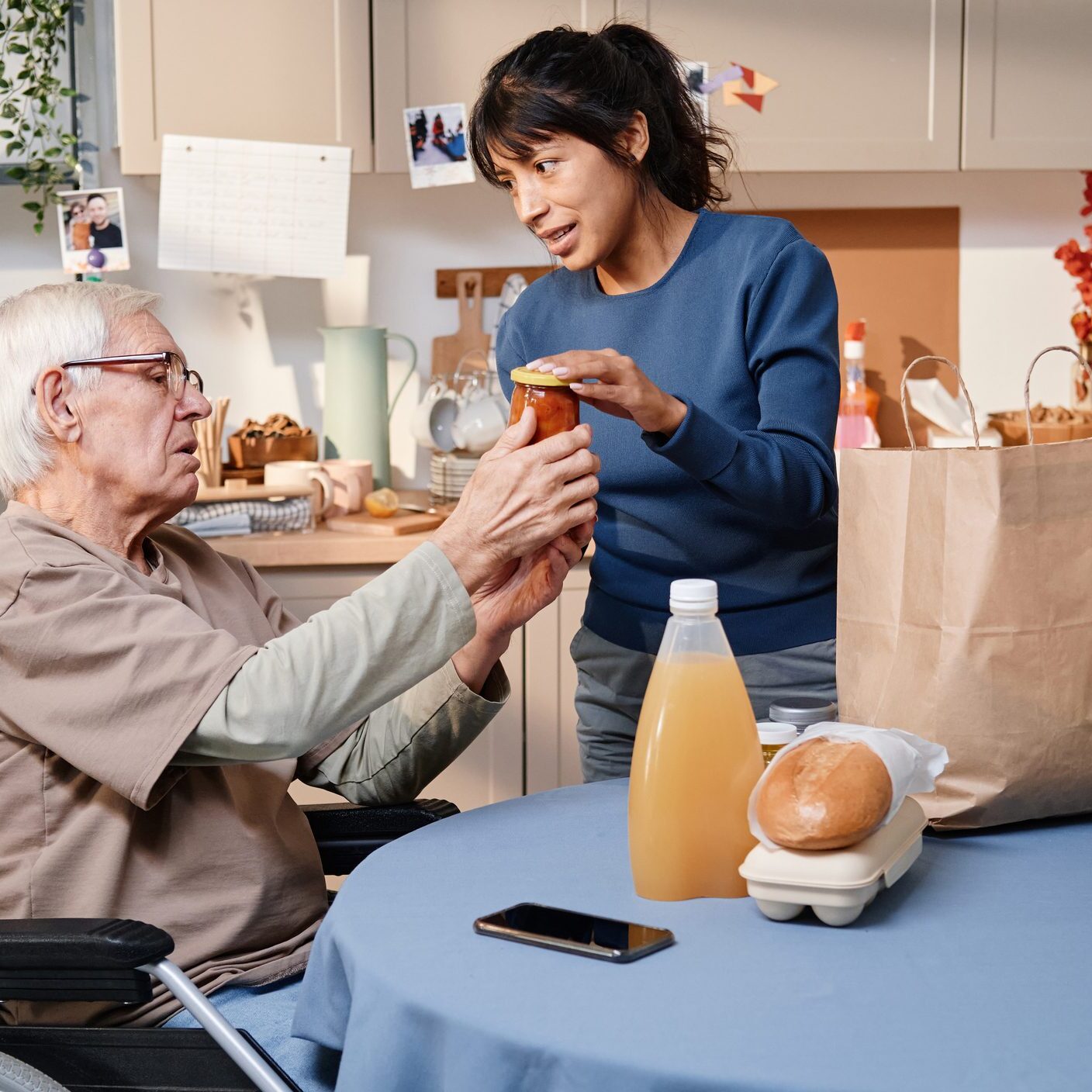 Woman helping elderly man with groceries