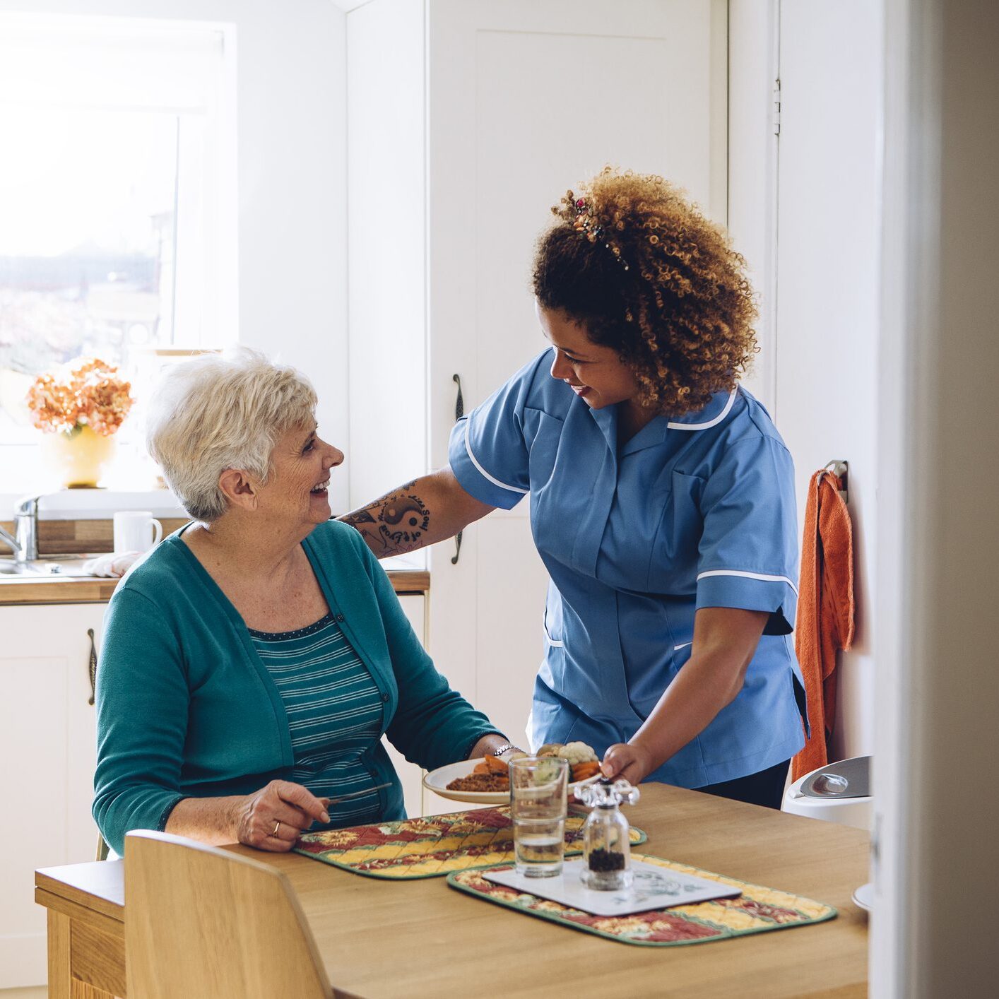 Nurse supporting older lady at home