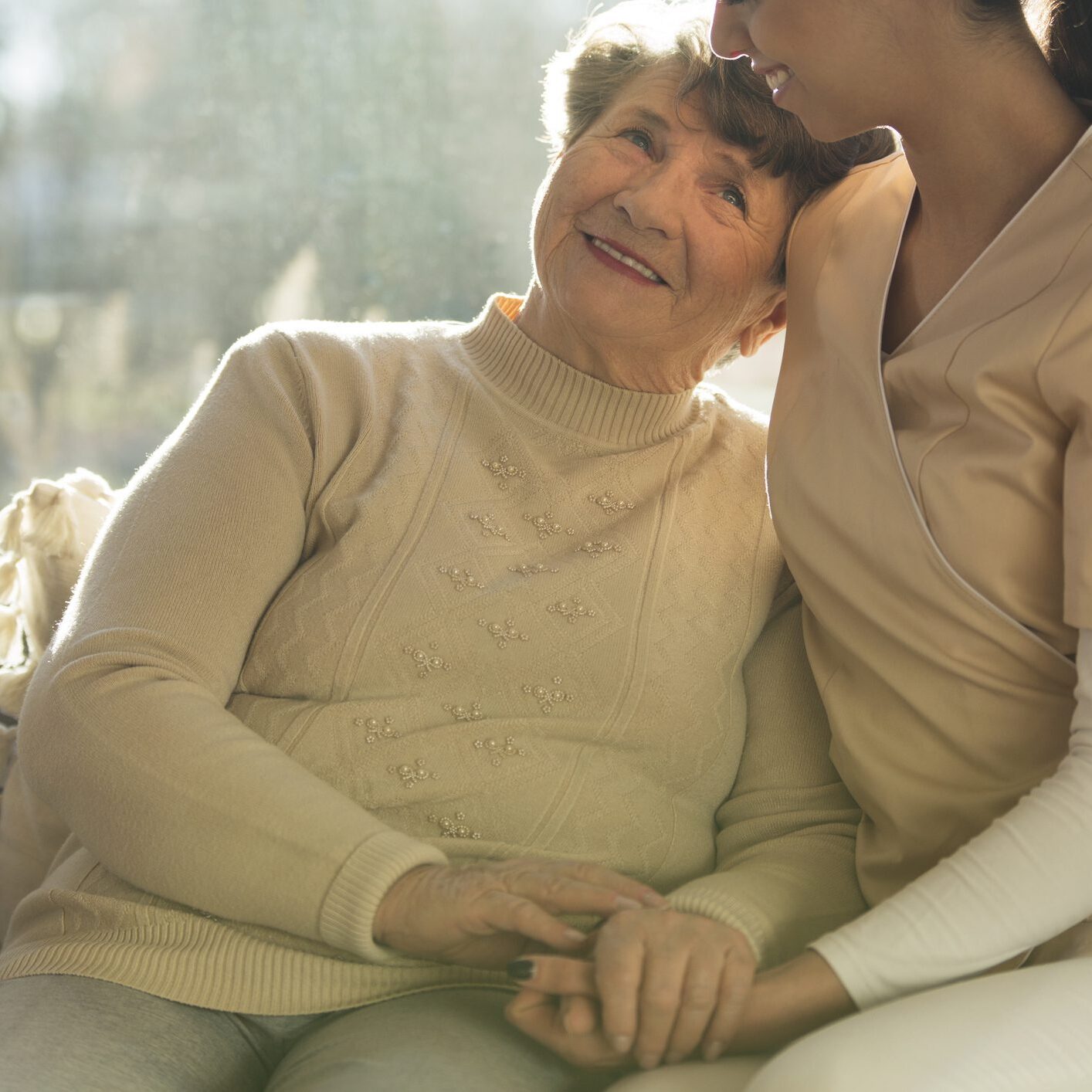 Senior woman smiling with caregiver's support